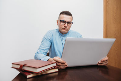 Young man using mobile phone while sitting on table