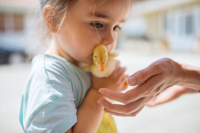 Mother gives a little duckling to her daughter.