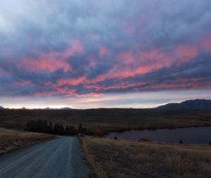 Country road against cloudy sky