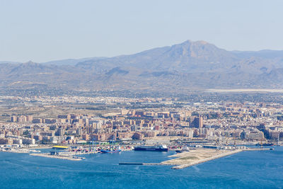 Sailboats in sea with city in background