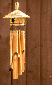 Close-up of electric lamp hanging on wooden wall