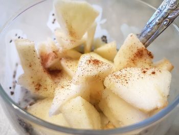 Dessert in a glass bowl - chia seeds in coconut yoghurt with apple slices and cinnamon sprinkle