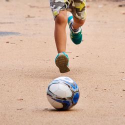 Low section of boy playing with ball