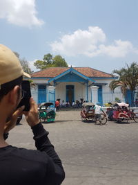 Man photographing against sky