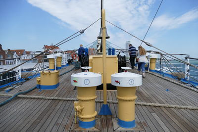 Rear view of people on boat against sky