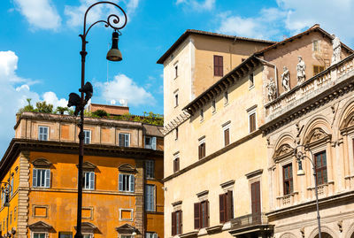 Low angle view of lamp post against buildings in city