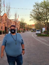 Portrait of man standing on street in city