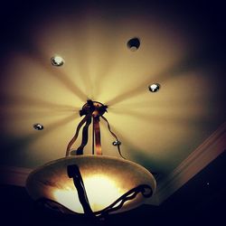 Low angle view of illuminated chandelier hanging from ceiling