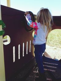 Rear view of girl standing against built structure
