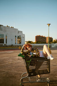 Mixed heritage asian-spanish young female posing with shopping cart