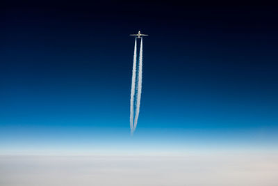 Low angle view of vapor trail against blue sky