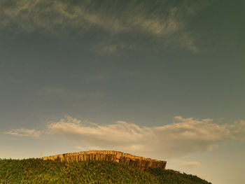 Low angle view of built structure on field against sky