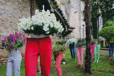 Low section of women standing by flowering plants