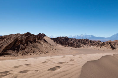 Scenic view of desert against clear blue sky