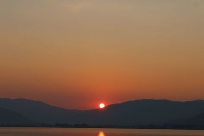 Scenic view of silhouette mountains against romantic sky at sunset