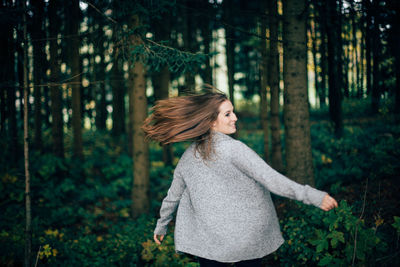 Young woman standing in forest