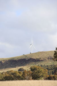 Windmill on field against sky