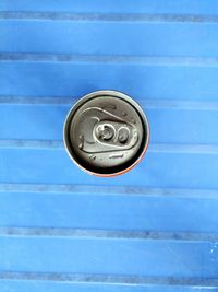 Directly above shot of drink can on blue bench