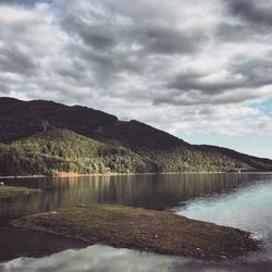 Scenic view of lake by mountain against sky