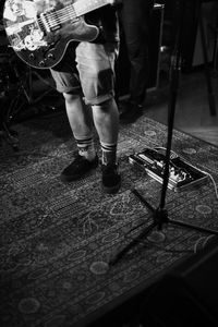 Low section of man standing on guitar