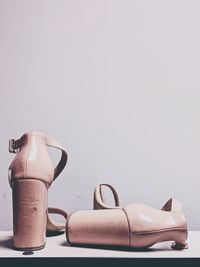 Close-up of shoes on table against white background