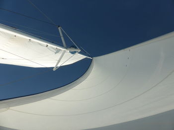 Low angle view of sailboat against clear blue sky