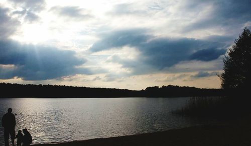 View of calm lake against cloudy sky