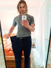 Full length of man photographing while standing on mobile phone