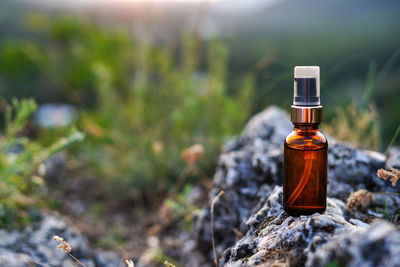 Essential oil staying on the stone, nature background with sunset