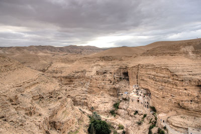 Scenic view of desert against cloudy sky