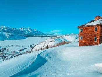 Snow covered buildings against blue sky