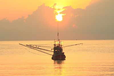 Silhouette sailboat in sea against sky during sunset