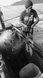 Man working on fishing boat in sea