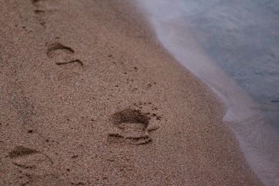 High angle view of footprints on sand at beach