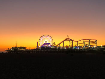 Silhouette ferris wheel against sky during sunset