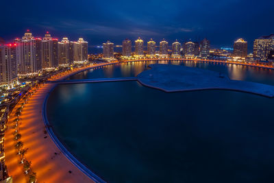 Illuminated buildings by swimming pool at night