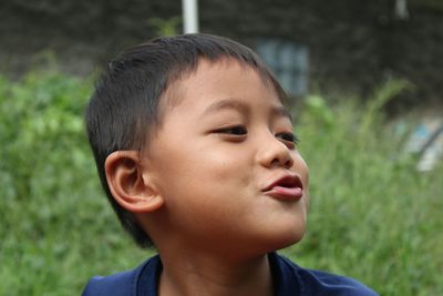 Close-up of cute boy puckering outdoors