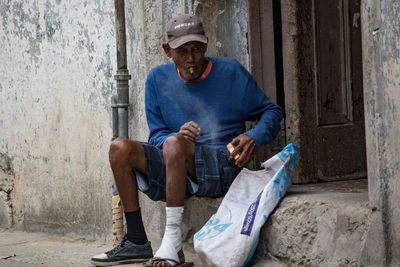 Portrait of a man sitting in alley