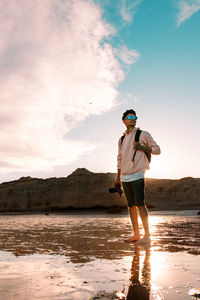 Full length of man standing on beach against sky