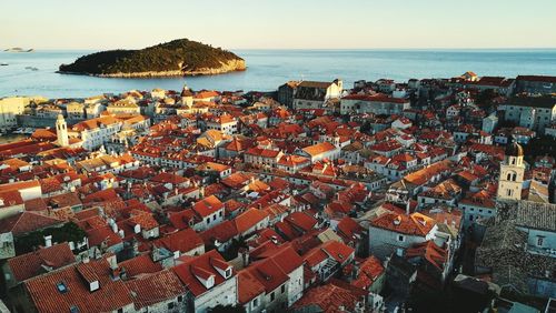 High angle view of cityscape by sea against sky