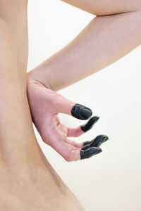 Close-up of woman holding hand over black background