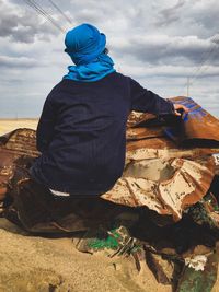 Rear view of man working on boat