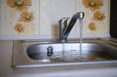 Close-up of faucet in bathroom at home