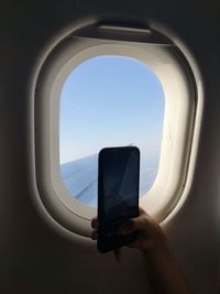Man photographing through airplane window