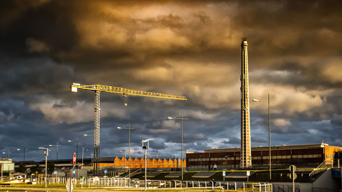 Cranes at construction site against sky