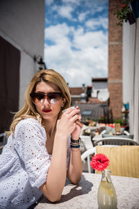 Side view of beautiful woman wearing sunglasses while sitting at cafe