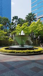 Fountain by trees in park against clear sky