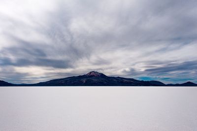 Scenic view of mountains against cloudy sky