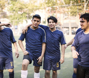 Happy soccer team standing at field