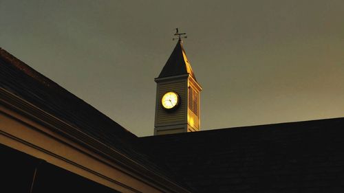 Low angle view of clock tower against sky at night